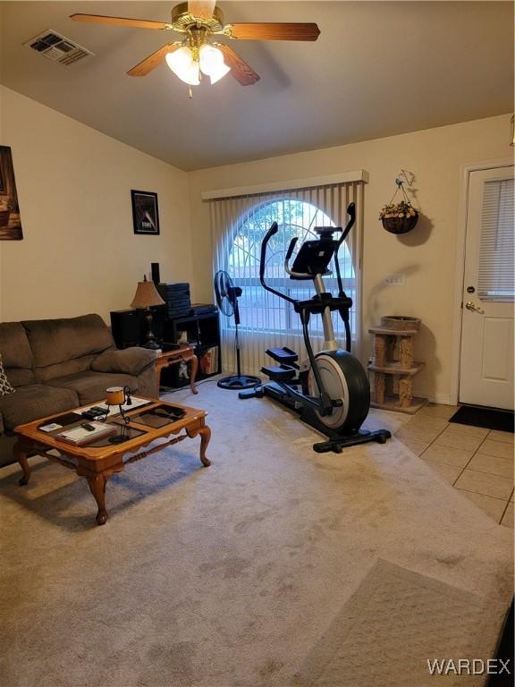 living room featuring visible vents, lofted ceiling, ceiling fan, light colored carpet, and light tile patterned floors