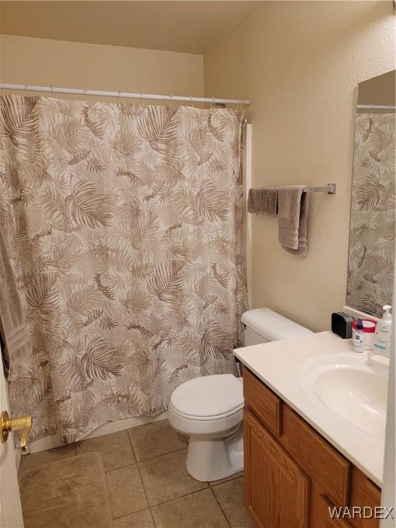 bathroom featuring vanity, tile patterned floors, a shower with curtain, and toilet