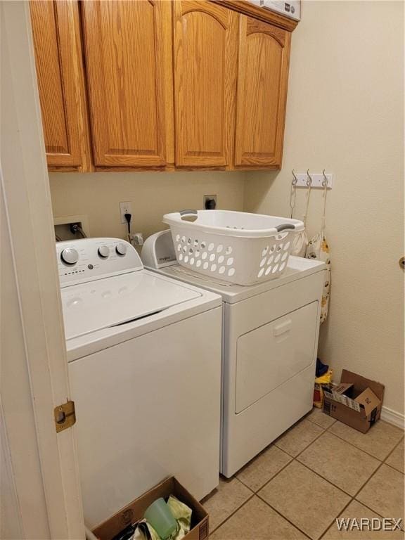 washroom featuring light tile patterned flooring, independent washer and dryer, and cabinet space