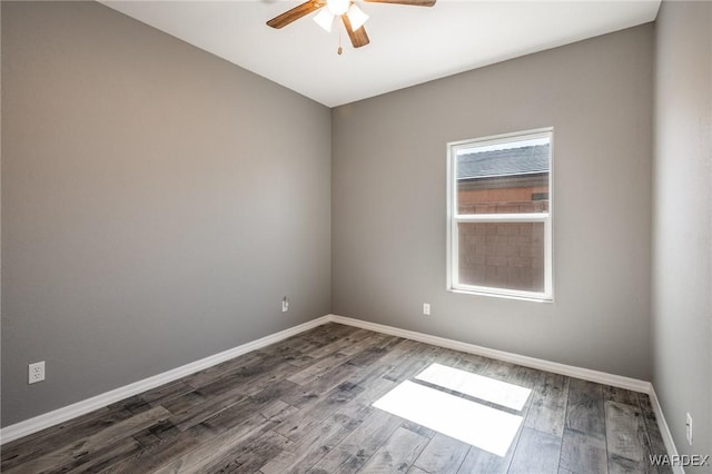 empty room featuring ceiling fan, dark wood-type flooring, and baseboards