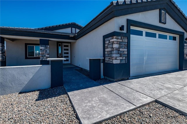 exterior space with a garage, stone siding, and stucco siding