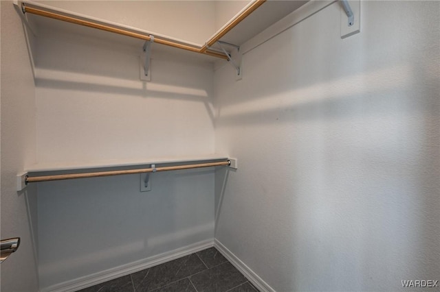 spacious closet with dark tile patterned flooring