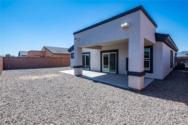 back of property featuring a fenced backyard, a patio, and stucco siding