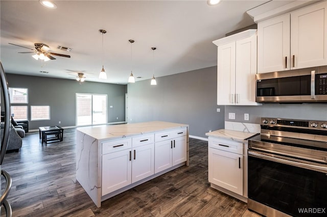 kitchen with appliances with stainless steel finishes, open floor plan, white cabinetry, and visible vents