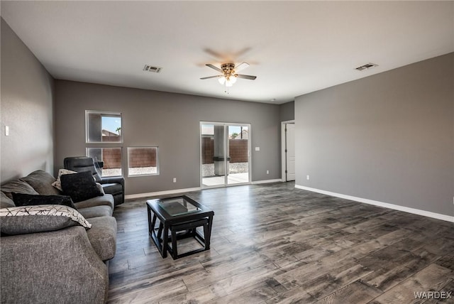 living area with dark wood-style floors, baseboards, and visible vents