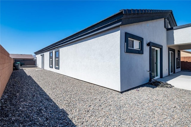 view of home's exterior with a patio area, a fenced backyard, and stucco siding