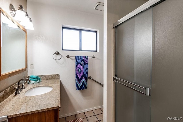 bathroom with a stall shower, vanity, baseboards, and tile patterned floors