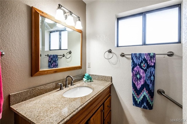 bathroom featuring a textured wall and vanity