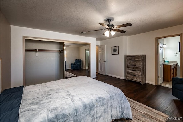 bedroom featuring a textured ceiling, dark wood-type flooring, visible vents, a ceiling fan, and a closet