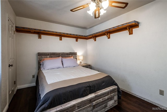 bedroom with baseboards, a ceiling fan, and dark wood-type flooring