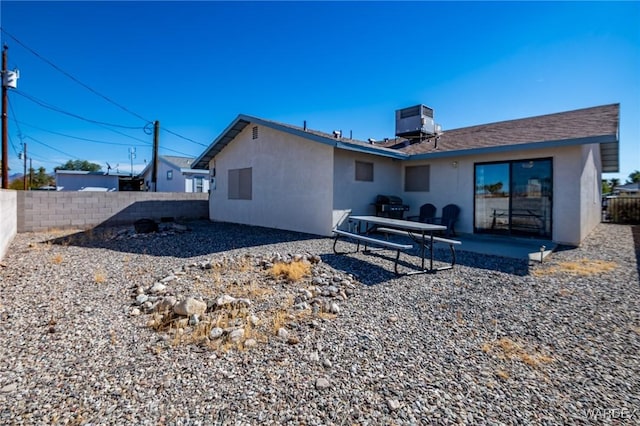 back of house with central air condition unit, a fenced backyard, a patio, and stucco siding