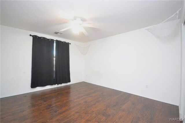 spare room with ceiling fan, visible vents, and wood finished floors