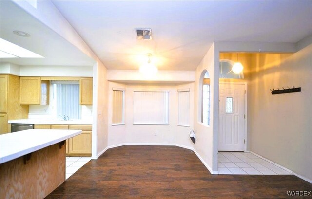 entryway with visible vents, light wood-style flooring, and baseboards