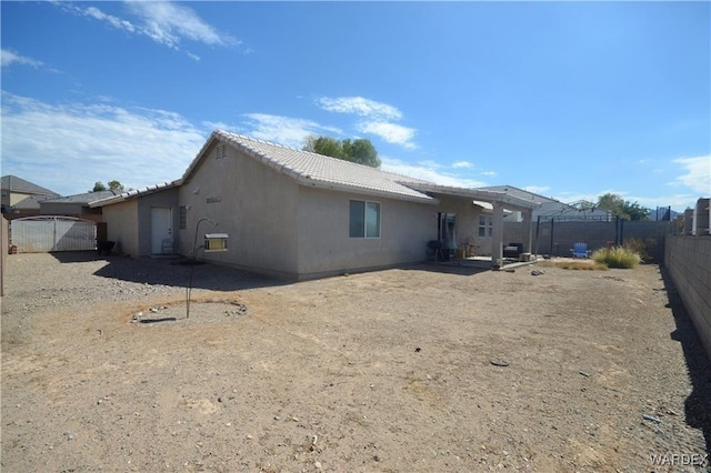 back of property with a fenced backyard, a tiled roof, and stucco siding