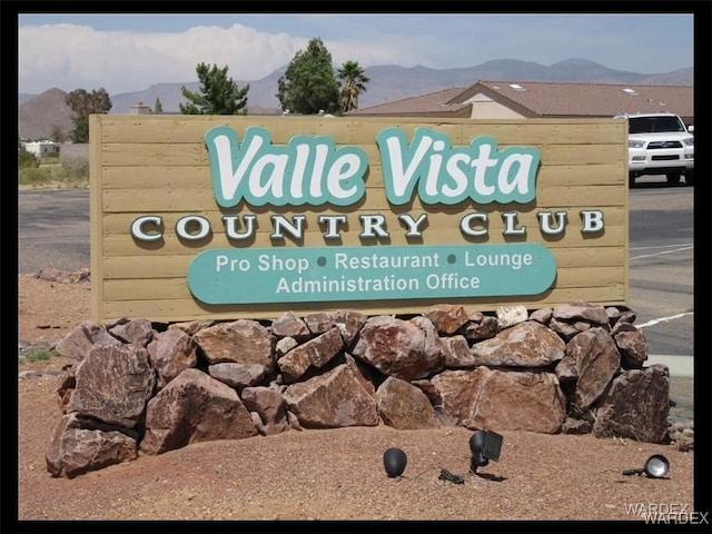 community / neighborhood sign with a mountain view