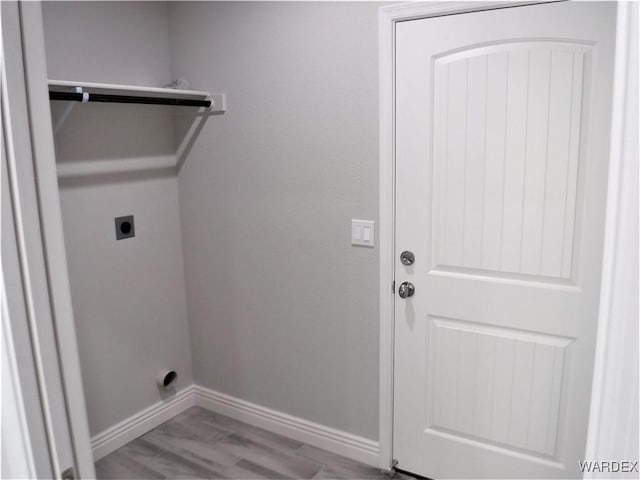 laundry area with laundry area, baseboards, light wood-style floors, and hookup for an electric dryer