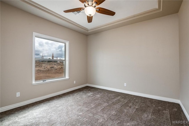 unfurnished room with a ceiling fan, visible vents, dark carpet, and baseboards