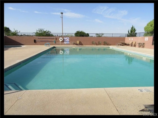 community pool featuring fence and a patio