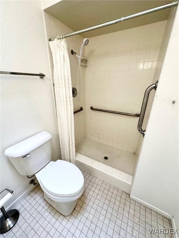 full bathroom with baseboards, a shower stall, and toilet