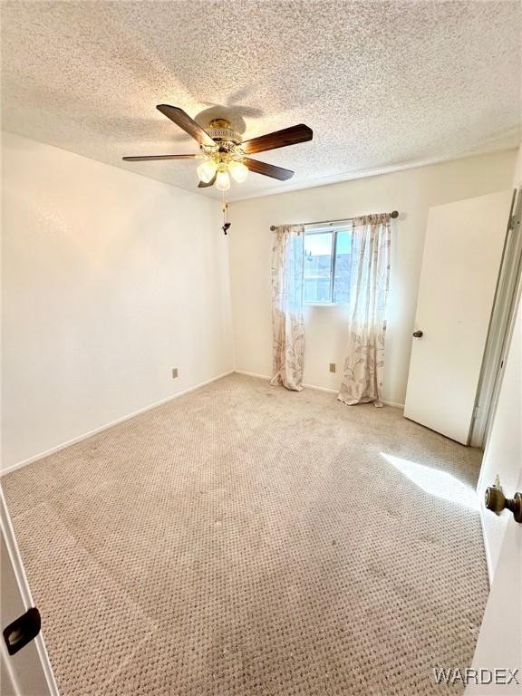 unfurnished room with light colored carpet, ceiling fan, and a textured ceiling