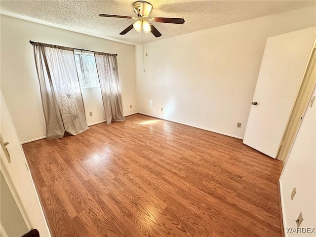 unfurnished bedroom featuring a textured ceiling, a ceiling fan, and light wood-style floors