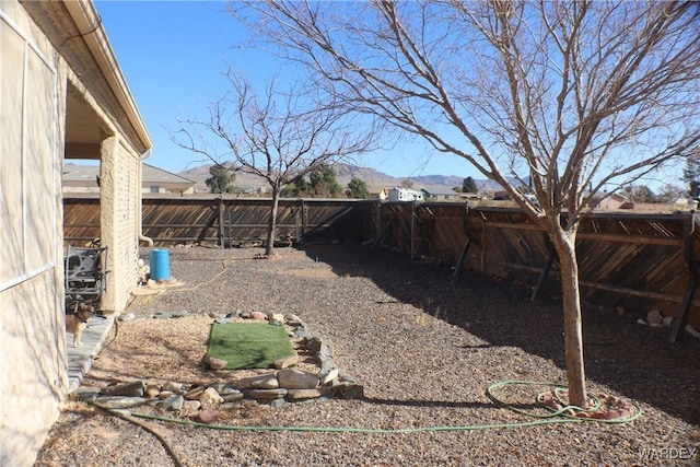 view of yard featuring a fenced backyard and a mountain view