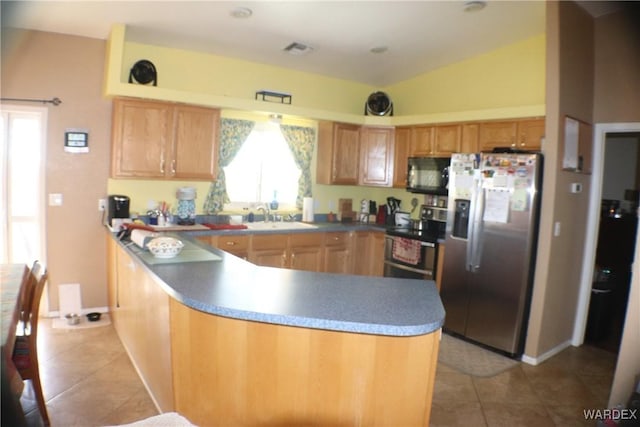 kitchen featuring light tile patterned flooring, a sink, visible vents, vaulted ceiling, and appliances with stainless steel finishes