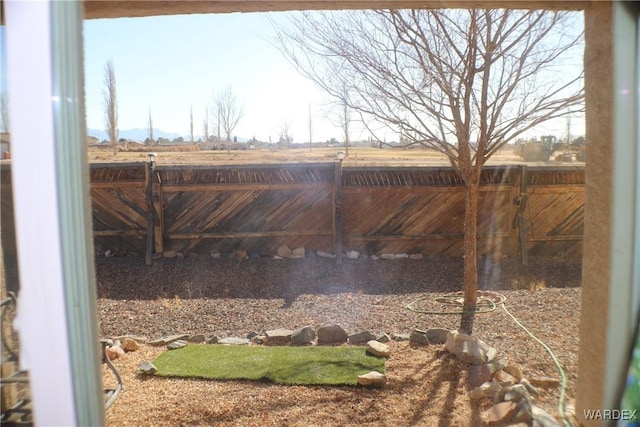 exterior space featuring a rural view and a fenced backyard