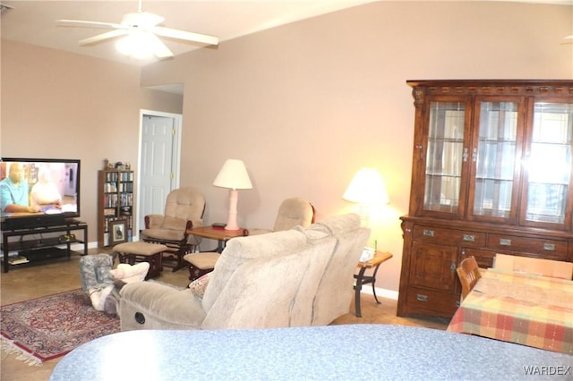 living room with baseboards, a ceiling fan, and carpet flooring