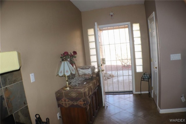 doorway to outside with baseboards and tile patterned floors