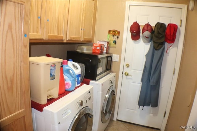 laundry room featuring light tile patterned floors, cabinet space, and washer and dryer