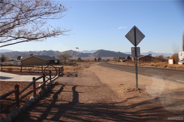 view of road with traffic signs, a rural view, and a mountain view