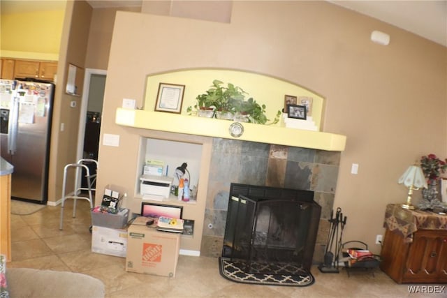 living room featuring vaulted ceiling, a fireplace, and light tile patterned flooring