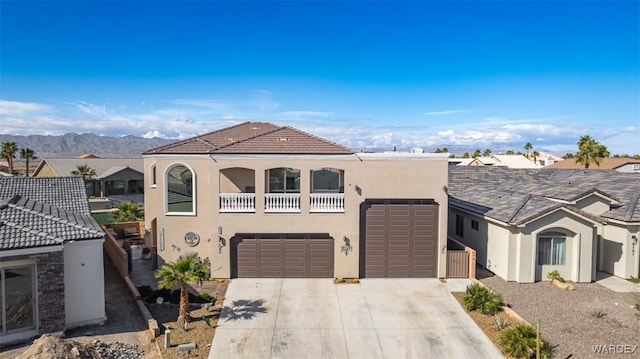 view of front of property with a mountain view, concrete driveway, and stucco siding