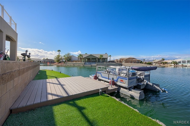 view of dock featuring a water view, boat lift, a residential view, and a yard