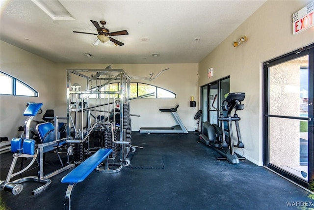 workout area featuring a ceiling fan and baseboards