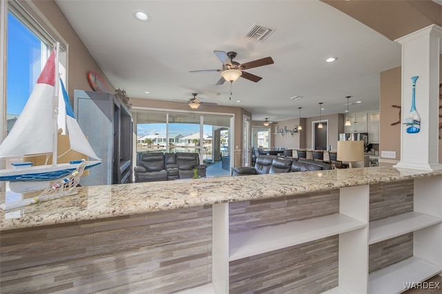 kitchen with recessed lighting, pendant lighting, visible vents, and light stone countertops