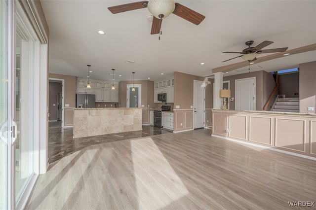 unfurnished living room featuring stairs, ceiling fan, recessed lighting, and light wood-style floors