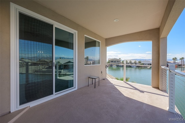 view of patio / terrace with a water view and a balcony