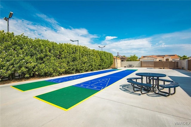 surrounding community featuring shuffleboard and fence