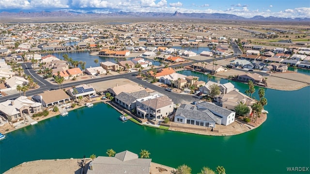 drone / aerial view with a water and mountain view and a residential view