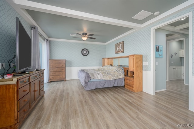 bedroom with ornamental molding, wainscoting, light wood-style flooring, and wallpapered walls