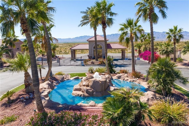 view of pool with a gazebo, fence, and a mountain view