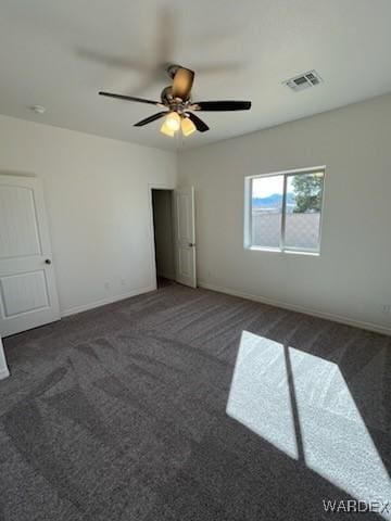 unfurnished bedroom with a ceiling fan, visible vents, dark carpet, and baseboards