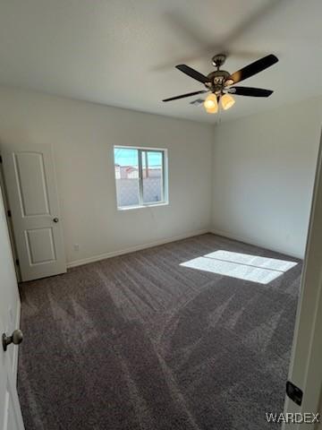 carpeted empty room featuring a ceiling fan and baseboards