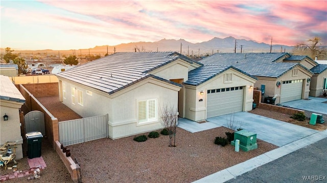 view of front of house with a tiled roof, a mountain view, driveway, and a garage