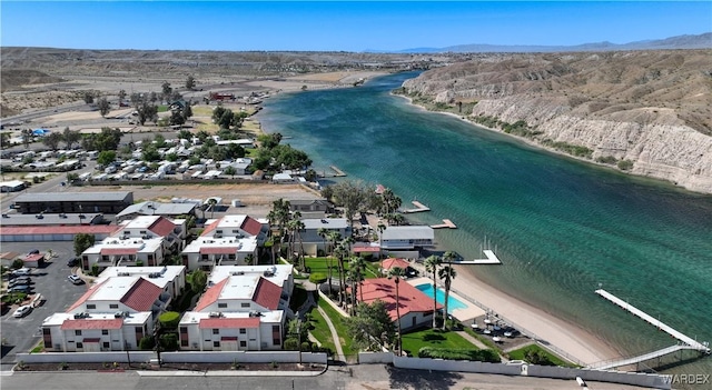 drone / aerial view featuring a residential view, a view of the beach, and a water and mountain view