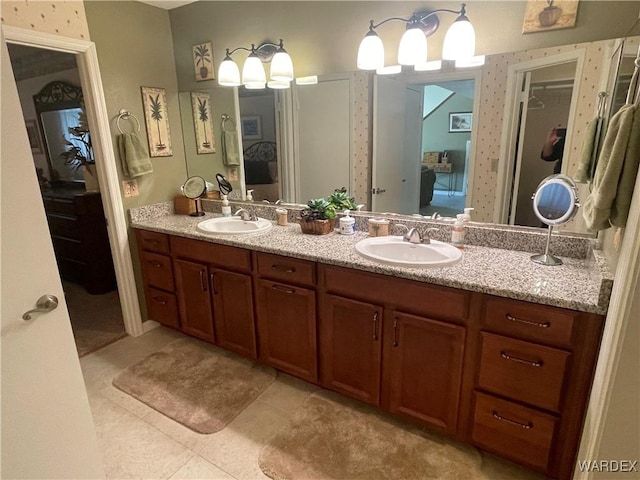 ensuite bathroom with double vanity, tile patterned flooring, a sink, and ensuite bathroom