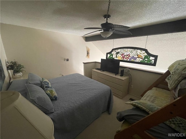 carpeted bedroom featuring a textured ceiling and ceiling fan