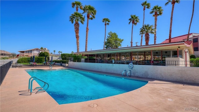 pool featuring a patio area and fence